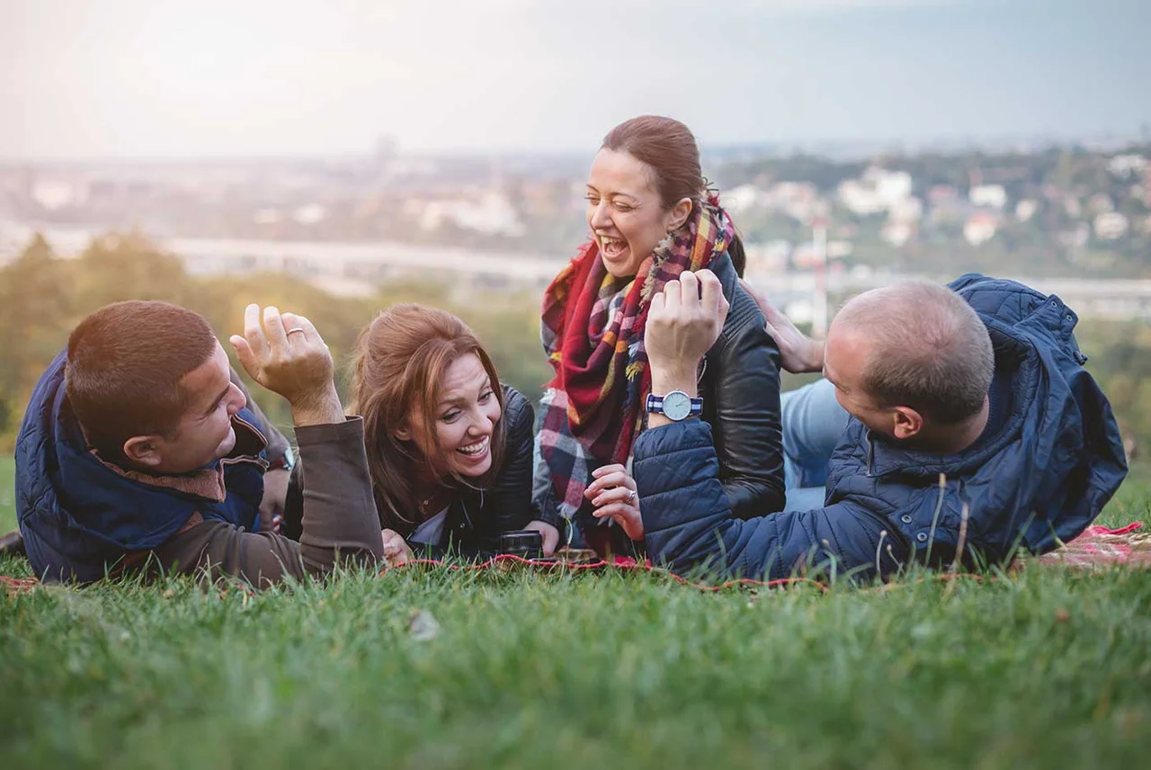 a group of people sitting in a grassy field