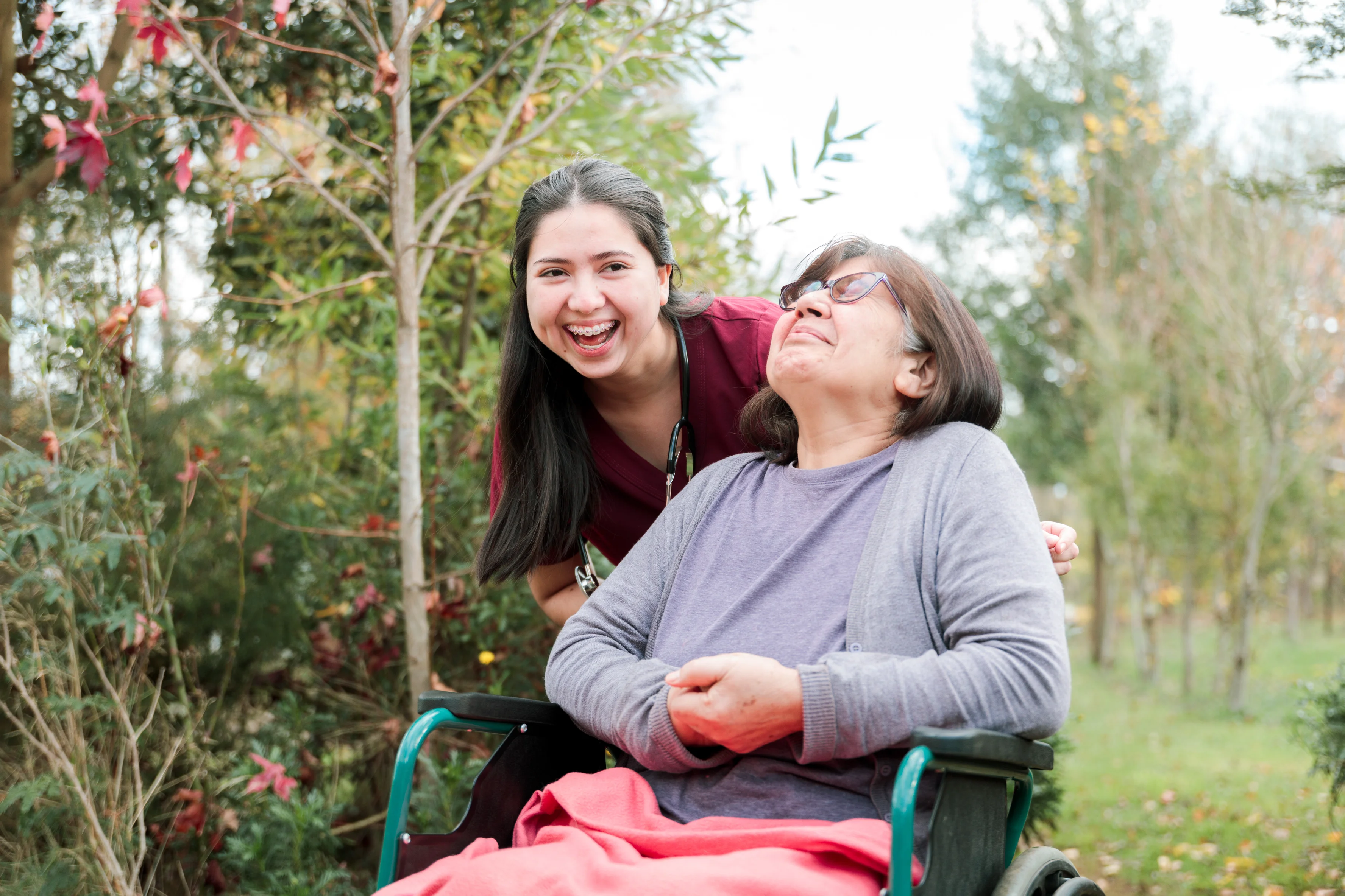 A laughing doctor and a smiling patient taking a walk in a garden