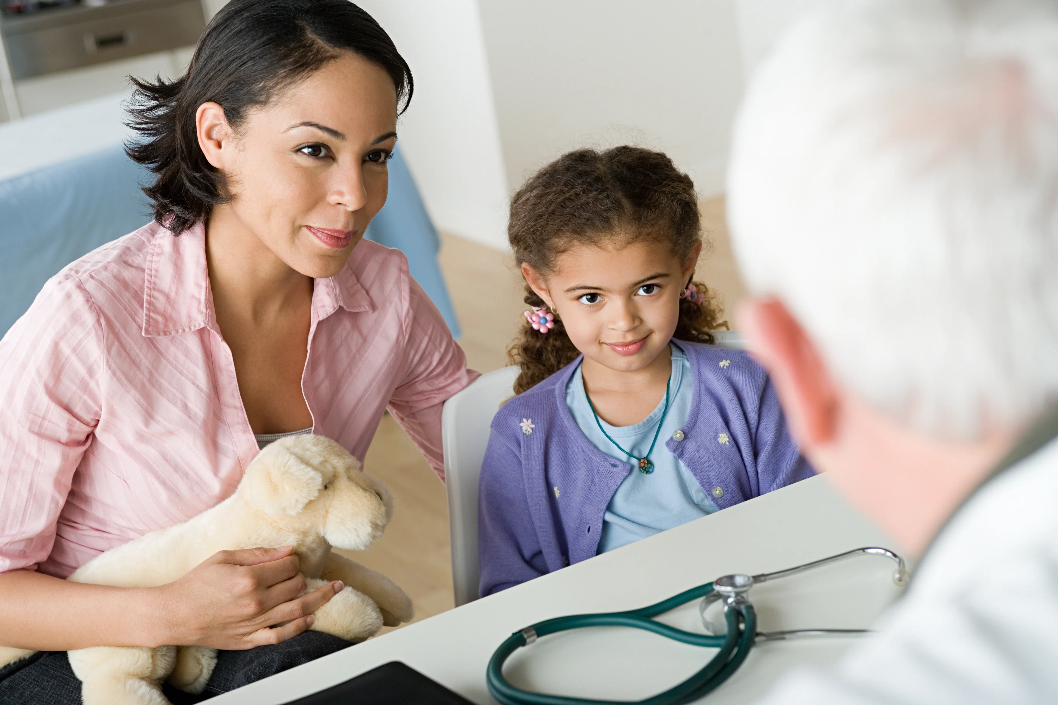 a doctor and a child looking at a stuffed animal