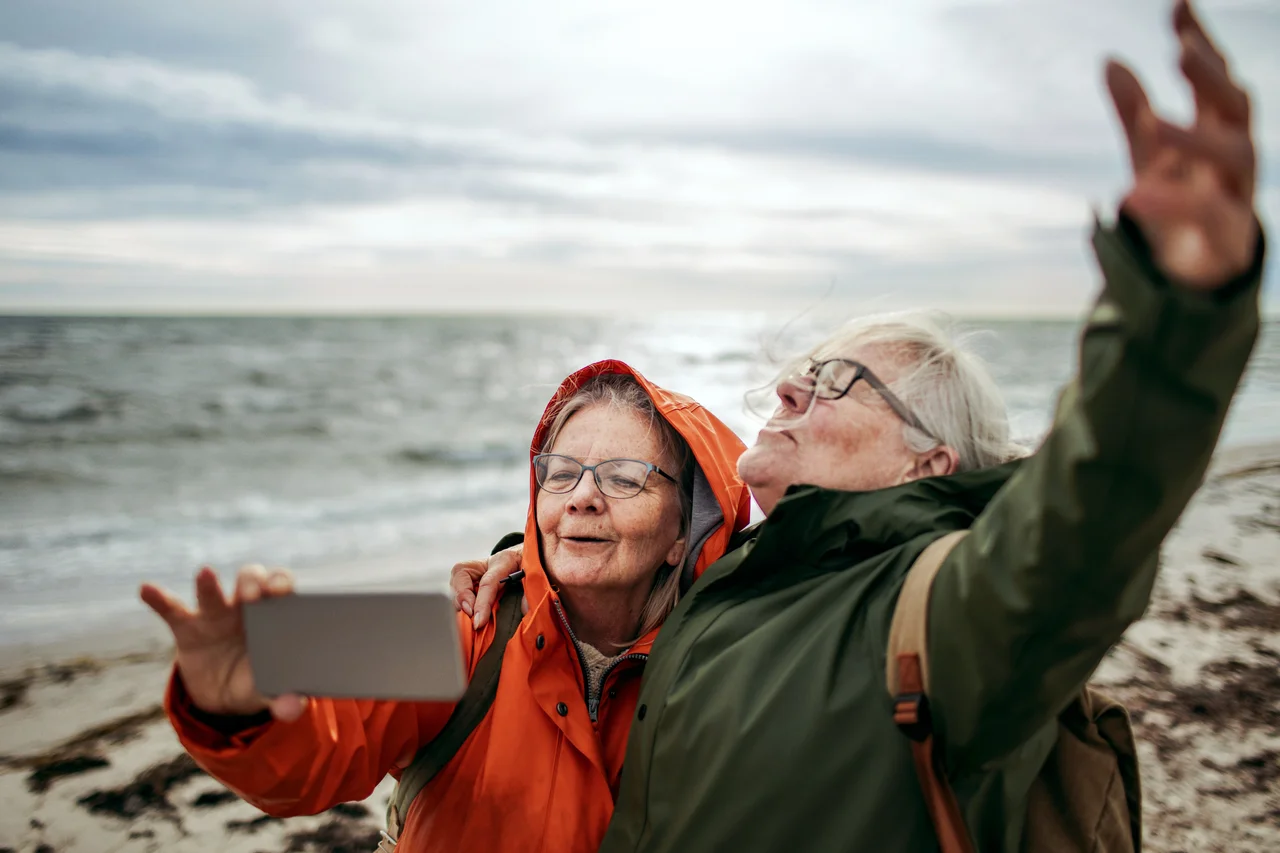 A couple taking a photo on a beach